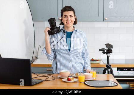 Essensfotograf mit Kamera in der Küche Stockfoto