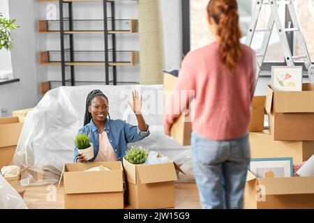 Frauen packen Kartons aus und ziehen in ein neues Zuhause Stockfoto