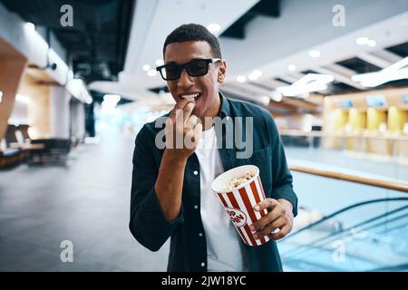 Fröhlicher Mann in 3D Gläsern mit Popcorn in den Händen. Ins Kino gehen. Stockfoto