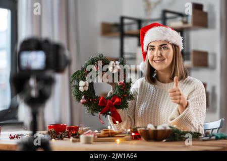 Frau mit Kamera und tannenweihnachtskranz zu Hause Stockfoto