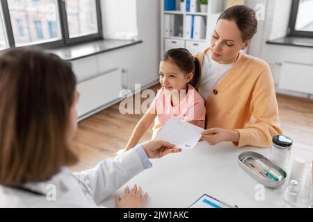 Mutter mit kleiner Tochter und Arzt in der Klinik Stockfoto