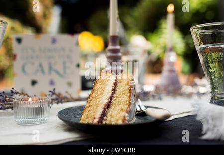 Ein Stück Kuchen auf einem dekorierten Esstisch Stockfoto
