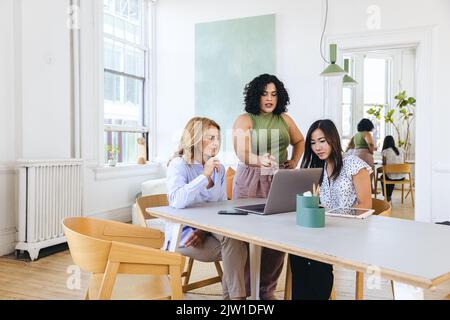 Junge Geschäftsfrau diskutiert Strategie mit Kollegen im Kreativbüro Stockfoto