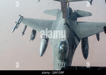 Eine F-16 Kampffalke, die der Expeditionary Fighter Squadron 79. zugewiesen wurde, erhält Lufttankungsunterstützung von einem KC-10 Extender, der der Expeditionary Air Fuel Squadron 908. zugewiesen wurde, über den Zuständigkeitsbereich des US Central Command, 31. August 2022. Die Mission der 9. Air Force (Air Forces Central) besteht darin, eine integrierte Kampagne mit regionalen und Koalitionsnationen durchzuführen, um regionale Aggressoren und globale Konkurrenten abzuschrecken und, falls nötig, zu besiegen. (USA Foto der Luftwaffe von Staff Sgt. Shannon Bowman) Stockfoto