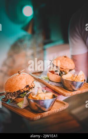 Kellner mit zwei Cheeseburgern und Pommes Stockfoto