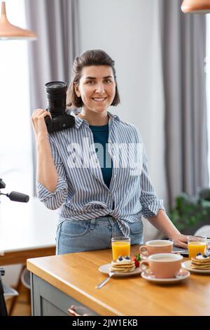 Essensfotograf mit Kamera in der Küche Stockfoto