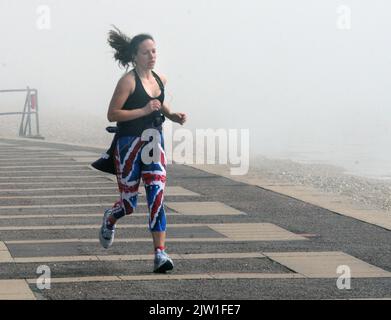 JOGGEN IM NEBEL AN DER KÜSTE VON SOUTHSEA, HANTS PIC MIKE WALKER, MIKE WALKER BILDER,2013 Stockfoto