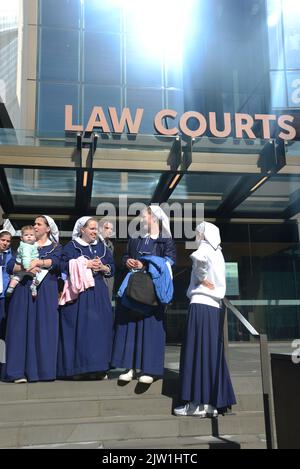 CHRISTCHURCH, NEUSEELAND, 29. AUGUST 2022: Mitglieder der Christlichen Gemeinde Gloriavale versammeln sich vor dem Gebäude des Justice Precinct in Christchurch, wo eine Anhörung über den Beschäftigungsstatus von Frauen in der Gemeinde im Gange war. Stockfoto