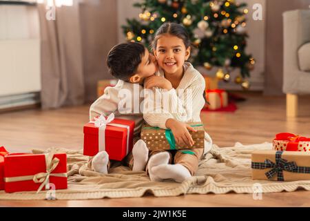 Junge küssen Schwester mit weihnachtsgeschenken zu Hause Stockfoto