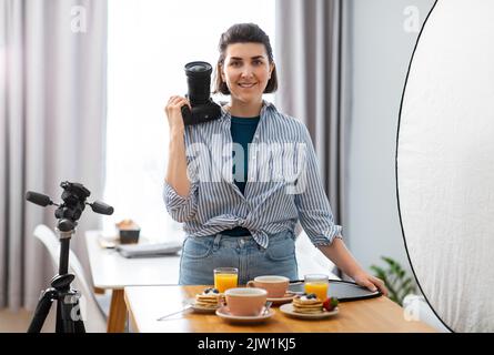 Essensfotograf mit Kamera in der Küche Stockfoto