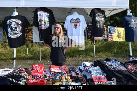 Wilkes Barre Township, USA. 02. September 2022. Eine Frau verkauft Trump-Waren am Straßenrand. Am Tag, bevor Präsident Trump bei einer Kundgebung in Wilkes-Barre sprechen soll, haben Händler aus dem ganzen Land entlang der Straße Geschäfte eingerichtet, um Waren zu verkaufen. Andere haben in der Arena gezeltet, um „First Row Joe's“ zu sein, um Karten für die Rallye zu bekommen, sobald sie können. Kredit: SOPA Images Limited/Alamy Live Nachrichten Stockfoto