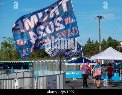 Wilkes Barre Township, Vereinigte Staaten. 02. September 2022. Ein Mann trägt eine 20 Meter hohe Trump-2024-Flagge. Am Tag, bevor Präsident Trump bei einer Kundgebung in Wilkes-Barre sprechen soll, haben Händler aus dem ganzen Land entlang der Straße Geschäfte eingerichtet, um Waren zu verkaufen. Andere haben in der Arena gezeltet, um „First Row Joe's“ zu sein, um Karten für die Rallye zu bekommen, sobald sie können. (Foto von Aimee Dilger/ SOPA Images/Sipa USA) Quelle: SIPA USA/Alamy Live News Stockfoto