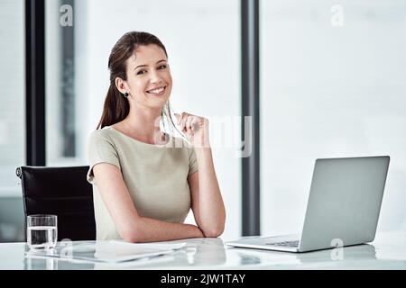 Meine Karriere bringt mir viel Glück. Porträt einer jungen Geschäftsfrau, die an ihrem Schreibtisch in einem Büro arbeitet. Stockfoto
