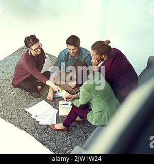 Es ist wichtig, gemeinsam im Team Entscheidungen zu treffen. Eine Gruppe junger Kreativer, die sich in einem modernen Büro treffen. Stockfoto