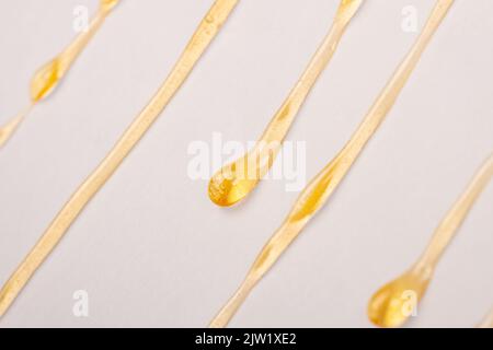 Cannabiswachsharz tropft aus der Nähe von weißem Papier herunter. Stockfoto