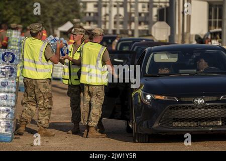 Jackson, USA. 02. September 2022. Mitglieder der Nationalgarde von Bravo Battery 1-104 aus Forest, MS, geben am Freitag, den 2. September 2022, Fälle von abgefülltem Wasser an Residenzen von Jackson, MS, aus. Jackson erlebt seinen fünften Tag ohne zuverlässige Wasserversorgung, nachdem der Pearl River überflutet wurde und die Hauptwasseraufbereitungsanlage zum Scheitern verurteilt war. Foto von Ken Cedeno/UPI Credit: UPI/Alamy Live News Stockfoto