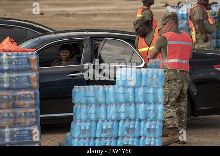 Jackson, USA. 02. September 2022. Mitglieder der Nationalgarde von Bravo Battery 1-104 aus Forest, MS, geben am Freitag, den 2. September 2022, Fälle von abgefülltem Wasser an Residenzen von Jackson, MS, aus. Jackson erlebt seinen fünften Tag ohne zuverlässige Wasserversorgung, nachdem der Pearl River überflutet wurde und die Hauptwasseraufbereitungsanlage zum Scheitern verurteilt war. Foto von Ken Cedeno/UPI Credit: UPI/Alamy Live News Stockfoto