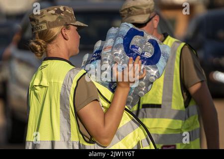 Jackson, USA. 02. September 2022. Mitglieder der Nationalgarde von Bravo Battery 1-104 aus Forest, MS, geben am Freitag, den 2. September 2022, Fälle von abgefülltem Wasser an Residenzen von Jackson, MS, aus. Jackson erlebt seinen fünften Tag ohne zuverlässige Wasserversorgung, nachdem der Pearl River überflutet wurde und die Hauptwasseraufbereitungsanlage zum Scheitern verurteilt war. Foto von Ken Cedeno/UPI Credit: UPI/Alamy Live News Stockfoto