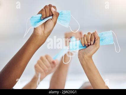 Feier des Endes der covid Pandemie mit Händen halten Gesichtsmaske im Arbeitsbüro, Erfolg und Solidarität nach covid 19 und Arbeitsplatz Glück Stockfoto