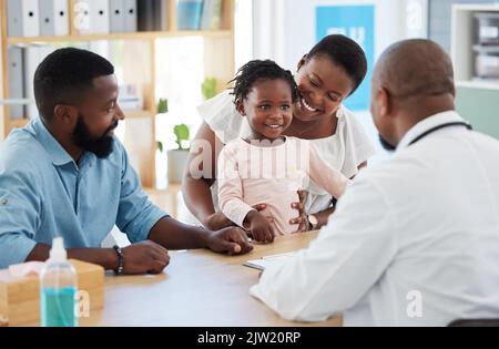 Schwarze Familie, Mädchen und Beratungsarzt im Krankenhaus, Gesundheitswesen und medizinischen Raum mit Mutter, Vater und Kindern. Lächeln, glücklich und vertrauen mit Stockfoto