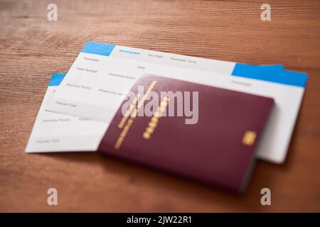 Ohne sie kommt es nicht weit. Zwei Flugtickets und ein Reisepass auf einem Tisch. Stockfoto