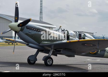 SM250 Doppelsitzer Spitfire rollt auf der Start- und Landebahn des Flughafens Solent. Sowohl Pilot als auch Beifahrer sind bei geöffnetem Vordach zu sehen. Stockfoto