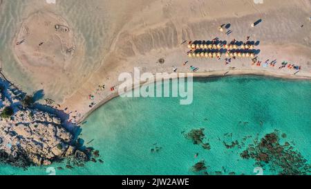 Drohnenaufnahme, direkt von oben, Detail, Felsen, zwei Reihen von Sonnenschirmen, Touristen, türkisfarbenes Meer, grünes Meer, Sandstrand, Blauer Himmel, Lagune, Strand Stockfoto