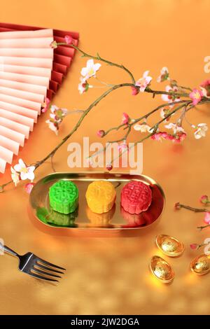 Farbenfrohe Mondkuchen mit Schneehaut, süßer Mochi-Mondkuchen, traditionelles chinesisches Dessert für das Herbstfest. Auf Goldplatte Stockfoto