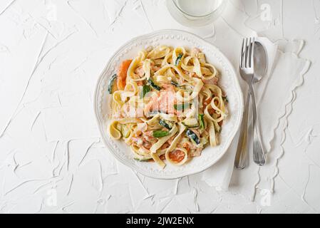 Meeresfrüchte-Tagliatelle-Pasta mit geräuchertem Lachs in Cremesauce. Gesunde vegetarische Mahlzeit Stockfoto