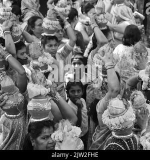 Delhi, Indien April 03 2022 - Frauen mit Kalash am Kopf während des Jagannath-Tempels Mangal Kalash Yatra tragen indische Hindu-Anhänger irdische Töpfe im Container Stockfoto