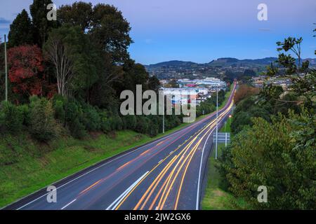 Die leichten Spuren von Autos, die in der Dämmerung von der Arbeit nach Hause fahren. Tauranga, Neuseeland Stockfoto