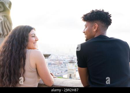Rückansicht eines jungen Mannes, der sich in der Stadt unterhielt, während er mit seiner Freundin in der Stadt stand Stockfoto