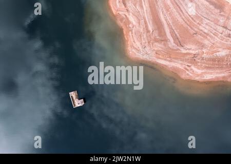 Blick von oben auf die Bergkette am Ufer des überfluteten Flusses mit Kirche in der Landschaft Stockfoto