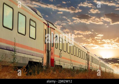 Doğu Express (türkisch: Doğu Express) ist ein Nachtzug der türkischen Staatsbahnen. Sonnenuntergang im Hintergrund. Stockfoto