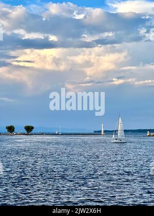 Segelboot, das vor dem Leuchtturm am Genfer See segelt Stockfoto