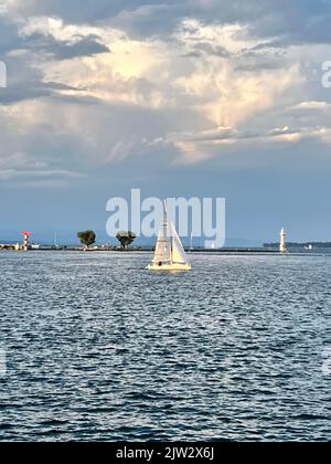 Segelboot, das vor dem Leuchtturm am Genfer See segelt Stockfoto