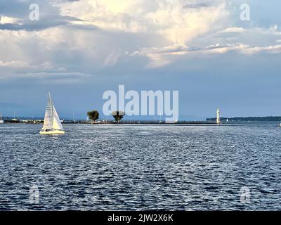 Segelboot, das vor dem Leuchtturm am Genfer See segelt Stockfoto