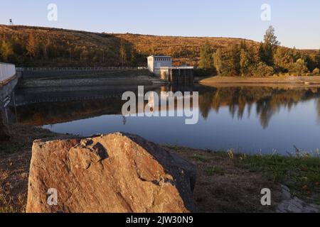 03. September 2022, Sachsen-Anhalt, Königshütte: Die Sonne geht über dem Damm auf. Einer der kältesten Orte Mitteldeutschlands an diesem Tag ist die Königshütte. In der Nacht fielen die Temperaturen auf fast den Gefrierbereich und lagen am frühen Morgen bei nur drei Grad Celsius. Foto: Matthias Bein/dpa/ZB Stockfoto