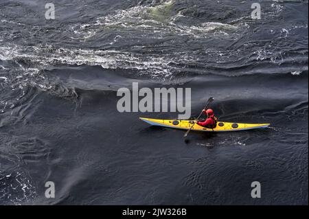 Blaues und gelbes Kajak auf offenem Wasser am Loch Lomond Stockfoto