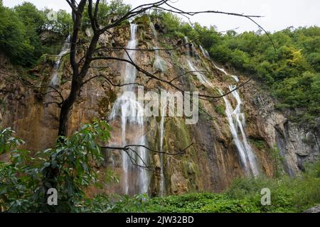 Wasser, das von den Felsen eines der vielen Wasserfälle im Nationalpark Plitvicer Seen, Kroatien, Europa, herabspritzt. Stockfoto