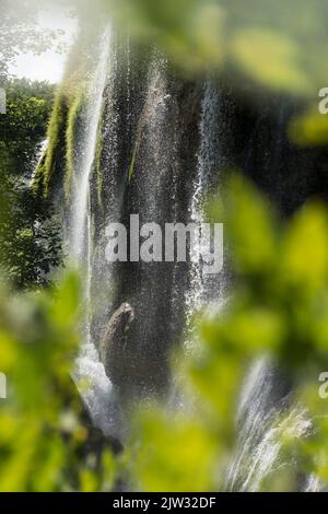 Wasser, das von den Felsen eines der vielen Wasserfälle im Nationalpark Plitvicer Seen, Kroatien, Europa, herabspritzt. Stockfoto