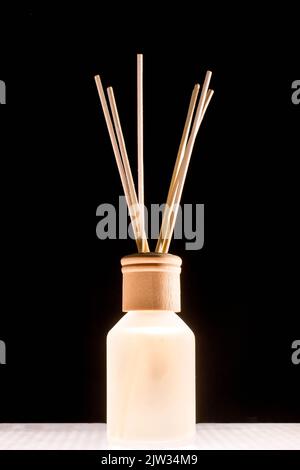 Duft für Zuhause. Aroma Diffusor Glas mit aromatischer Flüssigkeit und Bambusstäbchen. Stockfoto