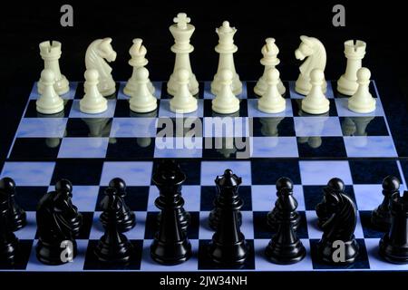 Schwarz-weiße Schachfiguren auf dem Schachbrett Stockfoto