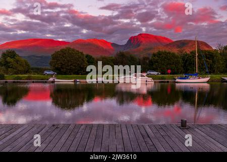 Blick über den Caledonian Canal bei Sonnenuntergang in Richtung Ben Nevis, dem höchsten Berg im Vereinigten Königreich Stockfoto