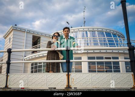 Eine vietnamesische Mutter mit ihrem vietnamesisch-britischen erwachsenen Sohn mit gemischter Rasse steht am Worthing Pier, West Sussex, Großbritannien, zusammen. Stockfoto