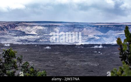 Dampf und Rauch steigen aus dem mächtigen Halemaumau-Krater. Der Lavasee im Krater ist noch aktiv. Dies ist ein heiliger Ort. Stockfoto