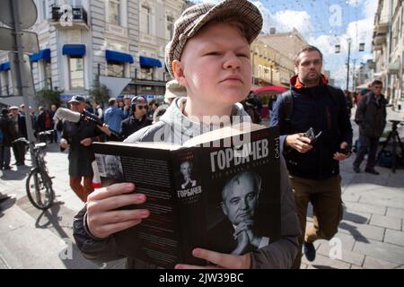 Moskau, Russland. 3.. September 2022. Ein junger Mann liest ein Buch von William Taubman vor dem Säulensaal des Hauses der Gewerkschaften, in dem in Moskau, Russland, ein Gedenkgottesdienst für Michail Gorbatschow abgehalten wird Stockfoto