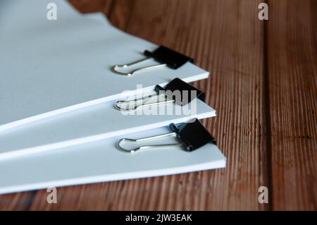 Papierstapel mit beschnittenen Dokumentenstapeln auf Holztisch. Konzept für Copy Space und Business Offices. Stockfoto