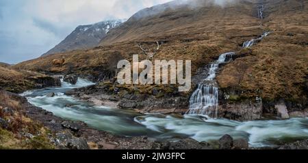 Zusammengesetztes Bild von Rothirsch in wunderschöner Winterlandschaft Bild von River Etive und Skyfall Etive Wasserfälle in schottischen Highlands Stockfoto