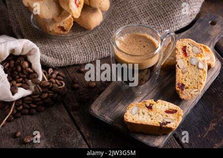 Traditionelle italienische Mandelkekse Biscotti serviert auf einem Holzbrett mit einer Tasse aromatischem Kaffee Stockfoto